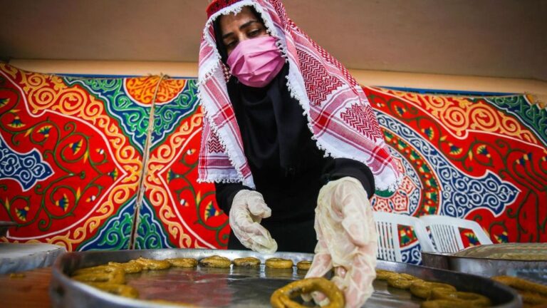 Una mujer palestina con mascarilla en Gaza preparando dulces tradicionales coronavirus
