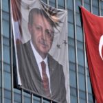 Retrato de Erdogan junto a una bandera de Turquía