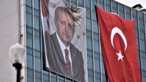 Retrato de Erdogan junto a una bandera de Turquía