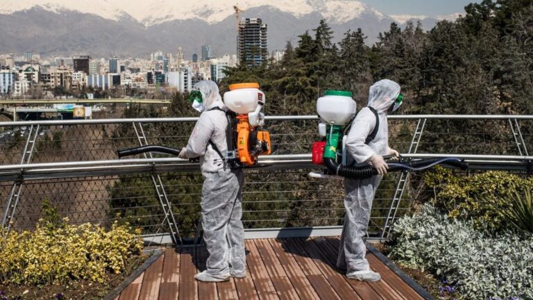 Trabajadores iraníes desinfectando un puente en Teherán