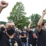 Trabajadores de Nissan Barcelona levantan el brazo como signo de protesta en la concentración convocada por el cierre de las plantas catalanas ante la fábrica de la compañía en Los Corrales de Buelna, Cantabria (España)