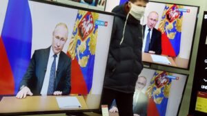 Un ciudadano en una tienda durante la retransmisión de un discurso del presidente Putin