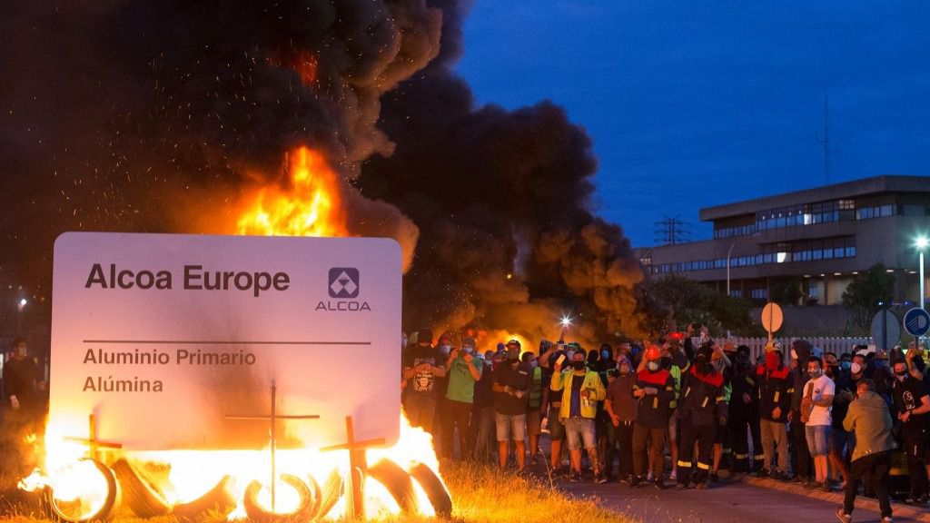 Manifestantes durante una concentración nocturna convocada por el comité de Alcoa San Cibrao, en el entorno de la fábrica de San Cibrao, queman el cartel de la multinacional en Lugo, Galicia (España), a 30 de junio. La manifestación, es una de las tantas