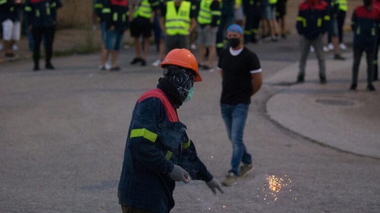Un manifestante tira un petardo durante una concentración nocturna convocada por el comité de Alcoa San Cibrao, en el entorno de la fábrica de San Cibrao