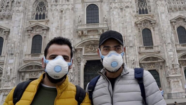 Turistas con mascarilla frente a la catedral de Milán