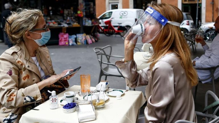 Dos personas sentadas en una terraza en Roma italia coronavirus