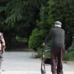 Una mujer y un hombre de edad avanzada pasen por la calle