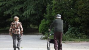 Una mujer y un hombre de edad avanzada pasen por la calle