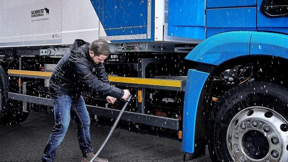 Un conductor cargando su camión eléctrico