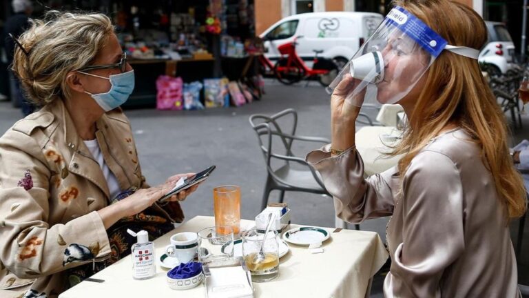 Dos personas sentadas en una terraza en Roma italia coronavirus