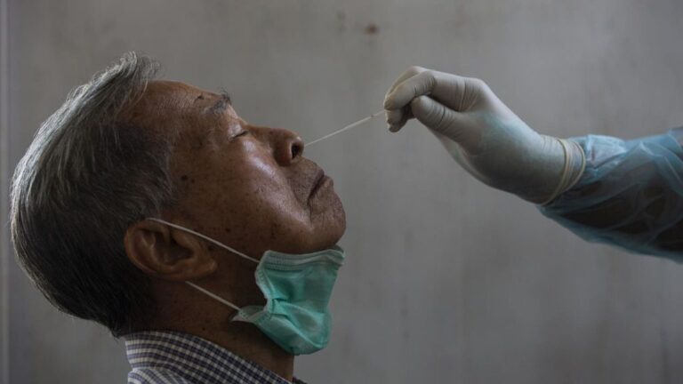 Un médico toma una muestra de un paciente para saber si tiene coronavirus.