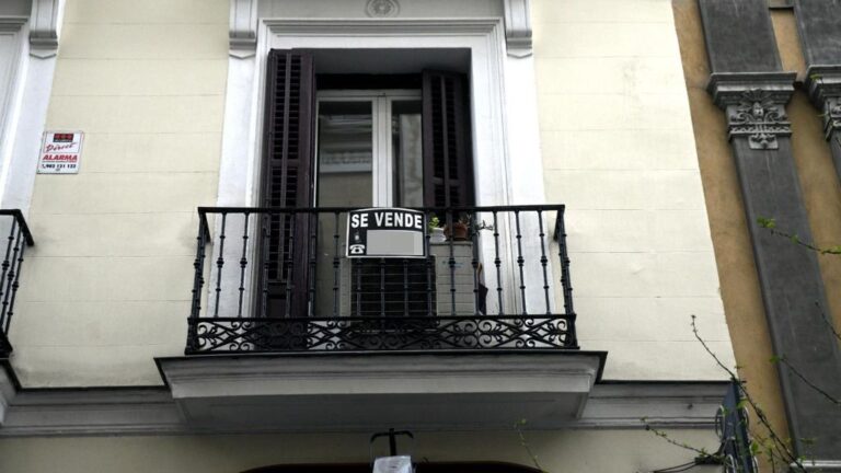 Cartel colgado en un edificio que indica que el inmueble está en venta.