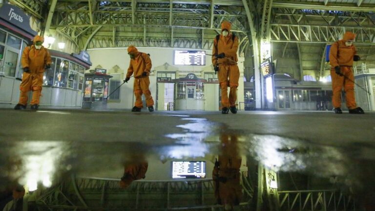 Trabajadores del Ministerio de Emergencias desinfectando una estación de trenes en San Petersburgo