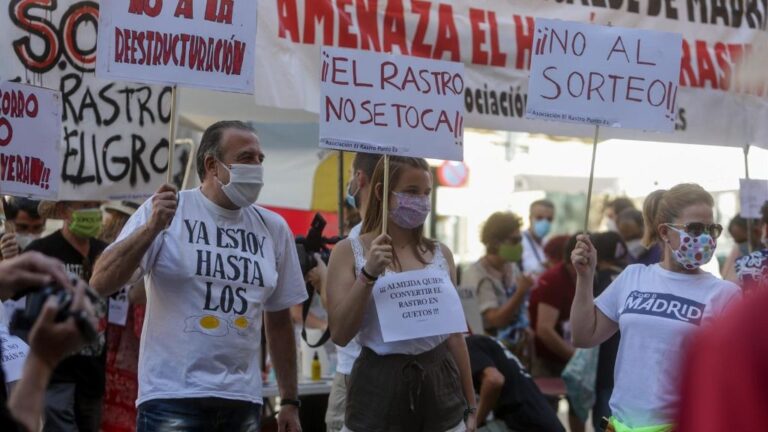 Comerciantes de El Rastro madrileño sostienen pancartas durante la manifestación en la Plaza del Cascorro para exigir sus puestos habituales y recuperar el modelo "histórico" del mercadillo.