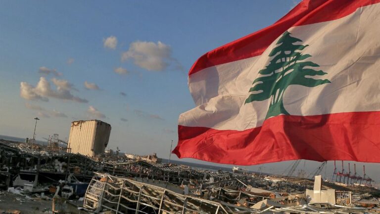 Una bandera de Líbano ondea junto a la zona destruida por la explosión en Beirut