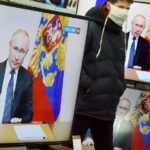 Un ciudadano en una tienda durante la retransmisión de un discurso del presidente Putin