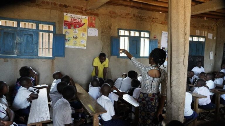 Niños en una escuela de RDC con un cartel sobre el ébola