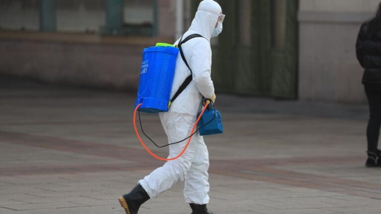 Un trabajador con un traje de protección en Pekín