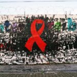Crespón rojo pintando en una pared, un gesto simbólico para reivindicar el Día Mundial de la lucha contra el VIH sida