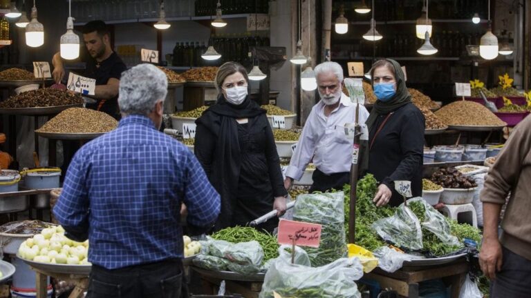 Personas con mascarilla enun mercado de Rasht, Irán