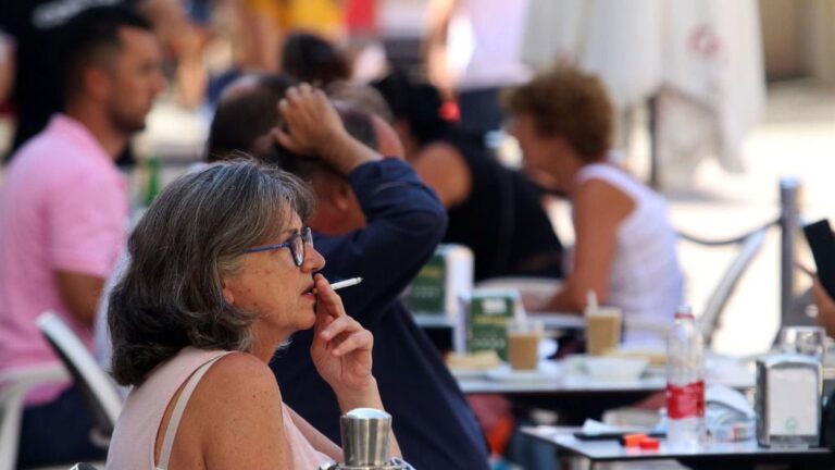 Personas fumando en terrazas y vías públicas durante el día en el que se ha decretado la prohibición de fumar en espacios públicos