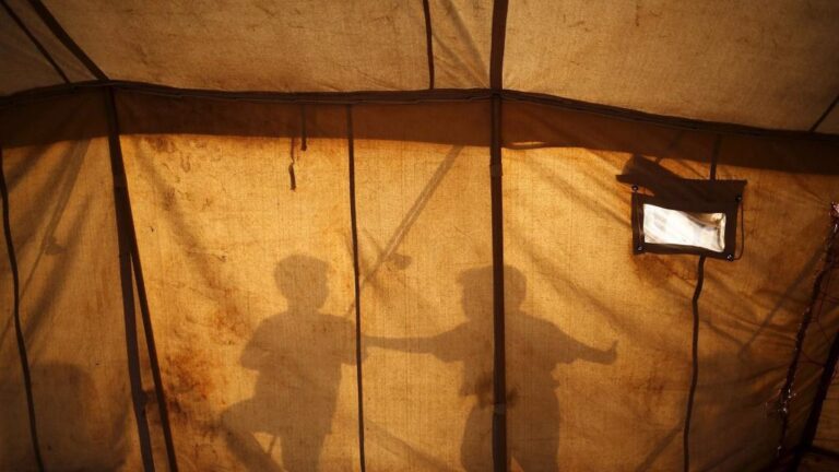 Sombras de dos niños refugiados en el campamento de Idomeni, en Grecia