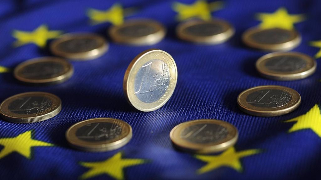 Monedas de euro sobre la bandera de la UE