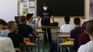 Un profesor y alumnos en un aula en el inicio del curso escolar en Roma