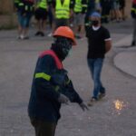 Un manifestante tira un petardo durante una concentración nocturna convocada por el comité de Alcoa San Cibrao, en el entorno de la fábrica de San Cibrao