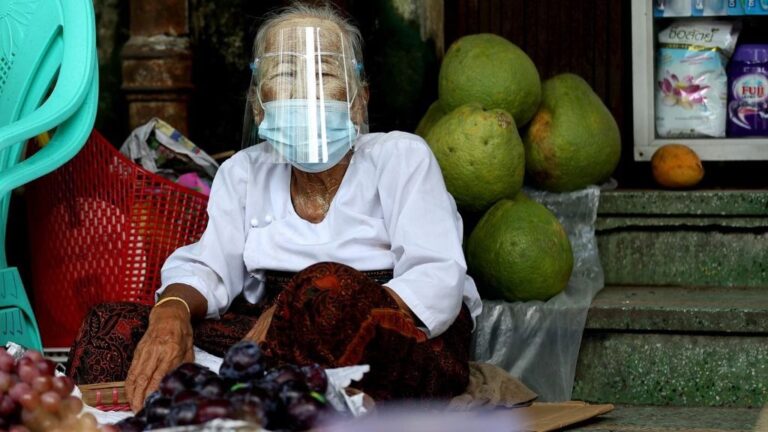 Una mujer con mascarilla en un mercado de Rangún