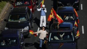 Varias personas participan con sus coches en la manifestación convocada por Vox