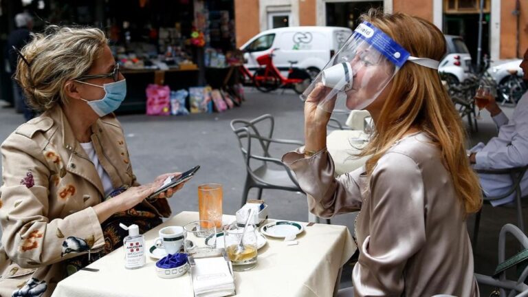 Dos personas sentadas en una terraza en Roma italia coronavirus