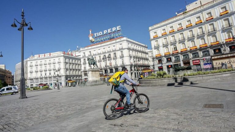Un 'rider' de Glovo circula por la Puerta del Sol el día, en Madrid