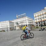 Un 'rider' de Glovo circula por la Puerta del Sol el día, en Madrid