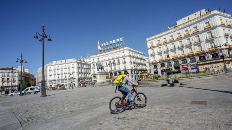 Un 'rider' de Glovo circula por la Puerta del Sol el día, en Madrid