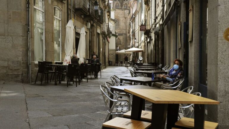 Una mujer permanece sentada en una terraza del barrio de O Coutoen Ourense