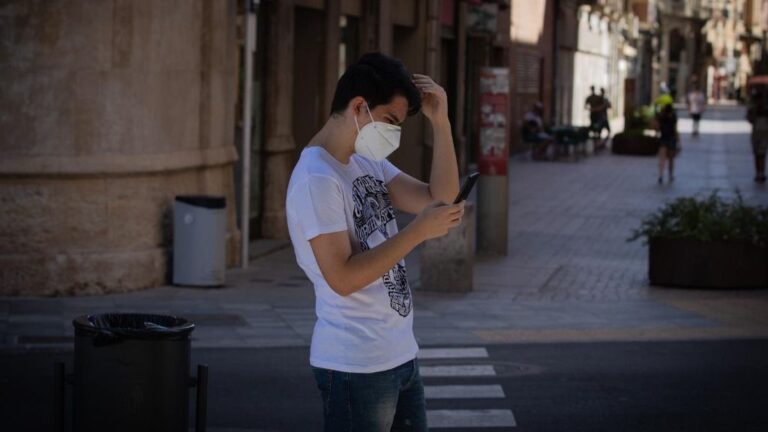 Un joven protegido con mascarilla camina por una calle del centro de Lleida, capital de la comarca del Segrià, en Lleida, Catalunya