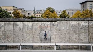 Un hombre con mascarilla pasando ante un muro de un museo en Niederkirchnerstrasse, en Berlín alemania coronavirus