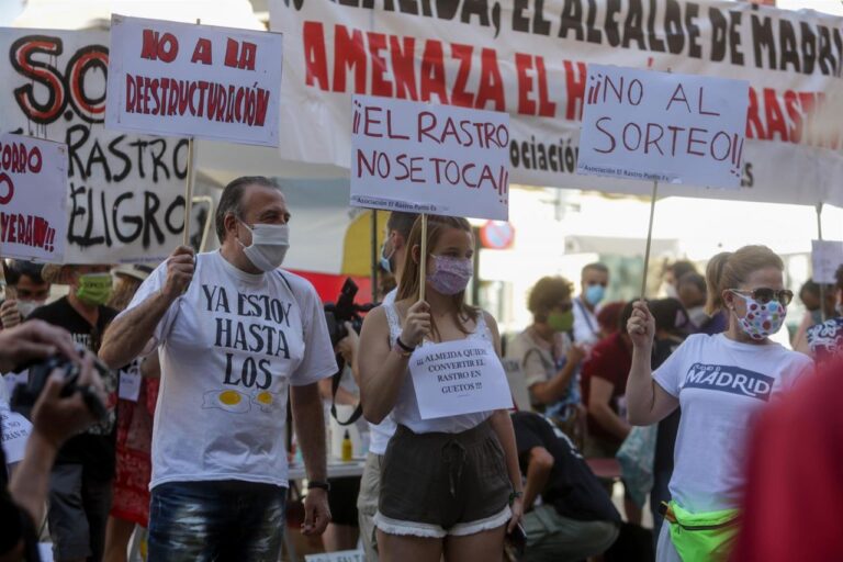 Comerciantes de El Rastro madrileño sostienen pancartas durante la manifestación en la Plaza del Cascorro para exigir sus puestos habituales y recuperar el modelo "histórico" del mercadillo.