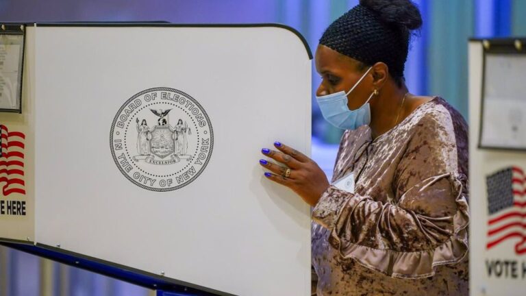 Una mujer con mascarilla vota en Nueva York