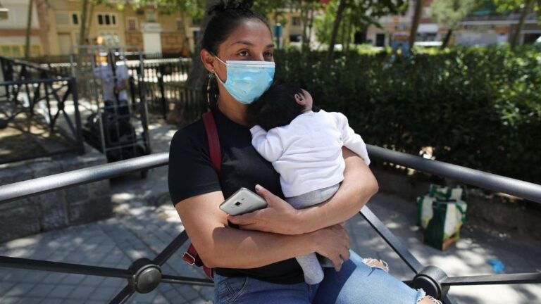 Lucía, una mujer con su bebé en brazos, acude a las puertas de la Parroquia Santa María Micaela para recibir una ayuda alimentaria. En Madrid (España), a 29 de mayo de 2020.