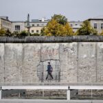 Un hombre con mascarilla pasando ante un muro de un museo en Niederkirchnerstrasse, en Berlín alemania coronavirus