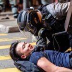 Un agente de Policía arroja a un manifestante al suelo durante un mitin