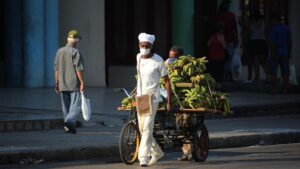 Un vendedor con mascarilla por el coronavirus en una calle de La Habana