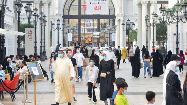 Personas con mascarilla en un centro comercial en Kuwait