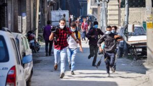 Un grupo de periodistas corre durante los enfrentamientos que tuvieron lugar en unas recientes manifestaciones en Cachemira por la muerte de tres personasa a manos de las autoridades de India