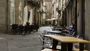 Una mujer permanece sentada en una terraza del barrio de O Coutoen Ourense