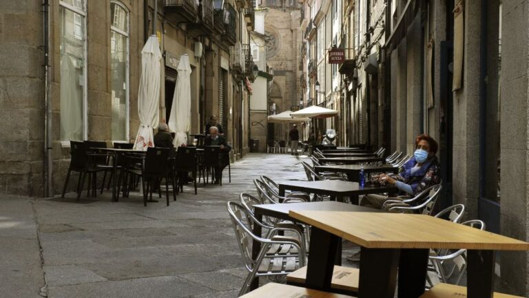 Una mujer permanece sentada en una terraza del barrio de O Coutoen Ourense