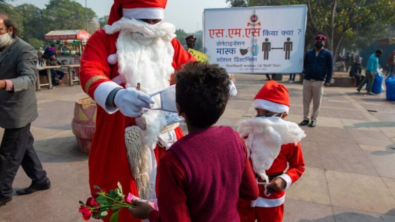 Un hombre disfrazado de Papá Noel reparte mascarillas en Nueva Delhi