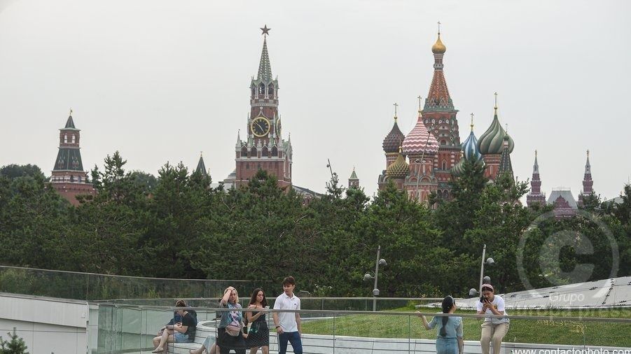 Personas en un parque de Rusia, con la catedral de San Basilio y el Kremlin al fondo
